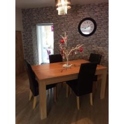 Oak effect dining table and 4 black leather effect chairs