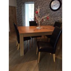 Oak effect dining table and 4 black leather effect chairs