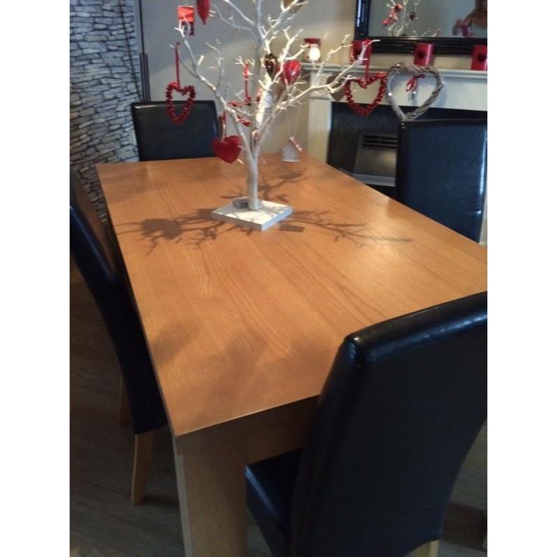 Oak effect dining table and 4 black leather effect chairs