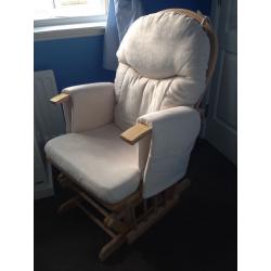 Glider reclining nursing chair and foot stool, cream coloured covers.