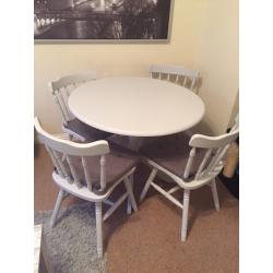 Grey kitchen dining table with four chairs and grey seat covers