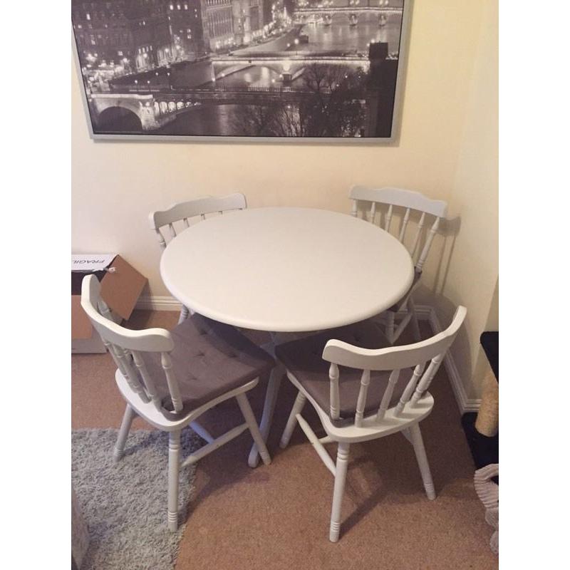 Grey kitchen dining table with four chairs and grey seat covers