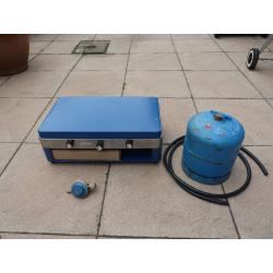 Camping stove with 2 burners and grill, gas bottle included.